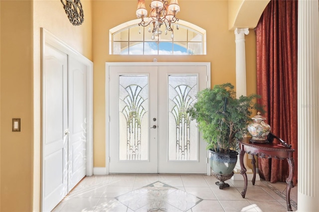 foyer featuring french doors, light tile patterned flooring, and ornate columns