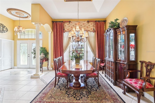 tiled dining area featuring decorative columns, french doors, a chandelier, and plenty of natural light