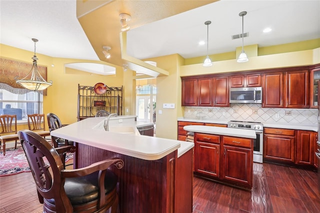 kitchen with stainless steel appliances, a wealth of natural light, and an island with sink