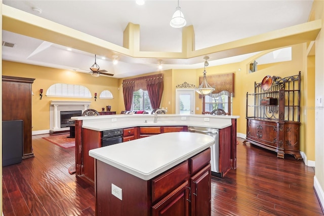 kitchen featuring a center island with sink, dark wood-type flooring, and pendant lighting