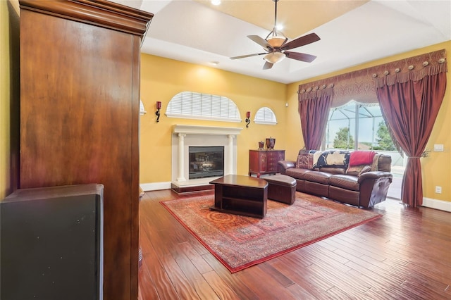 living room featuring ceiling fan and dark hardwood / wood-style flooring