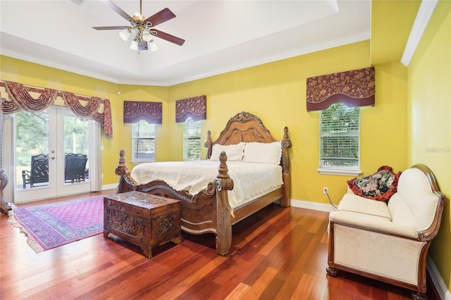 bedroom featuring a raised ceiling, ceiling fan, access to outside, hardwood / wood-style flooring, and french doors