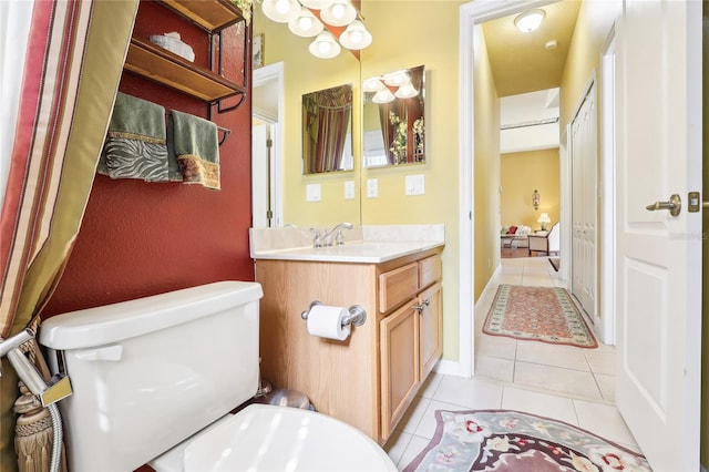 bathroom with toilet, vanity, and tile patterned flooring