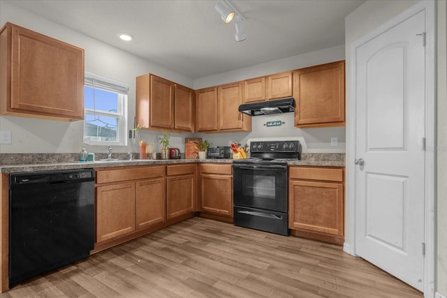 kitchen with black appliances, sink, and light wood-type flooring