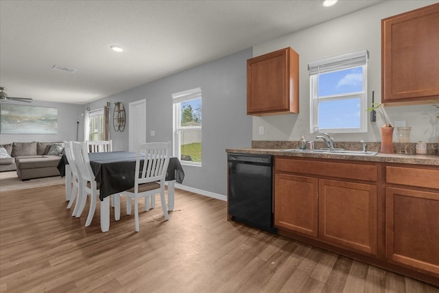 kitchen with black dishwasher, sink, light hardwood / wood-style floors, and ceiling fan