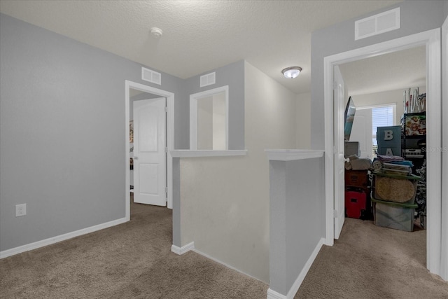 corridor featuring carpet and a textured ceiling