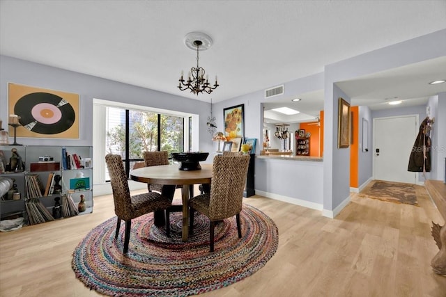 dining room featuring a notable chandelier and light hardwood / wood-style floors