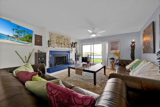 living room featuring a tile fireplace and ceiling fan