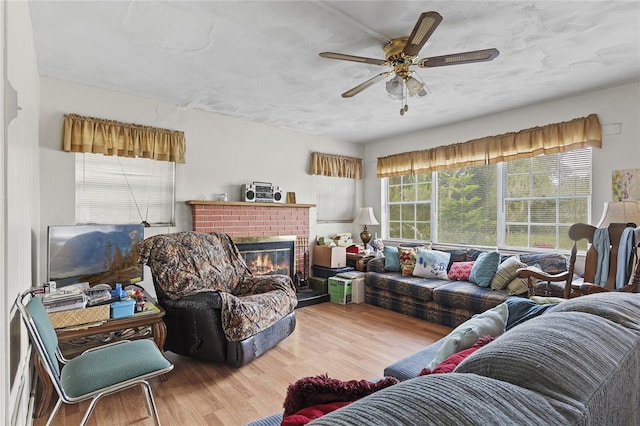 living room featuring ceiling fan, wood-type flooring, and a fireplace