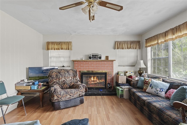 living room featuring hardwood / wood-style flooring, a fireplace, and ceiling fan