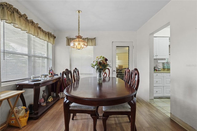 dining room with light hardwood / wood-style flooring and a chandelier