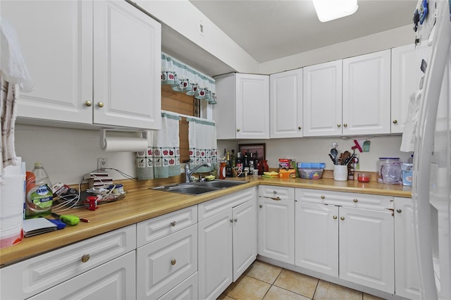 kitchen with white cabinetry, sink, and light tile patterned floors