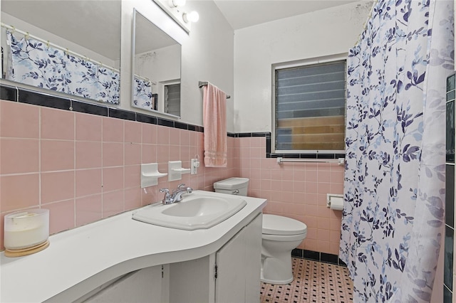 bathroom with tile walls, vanity, toilet, and tile patterned flooring