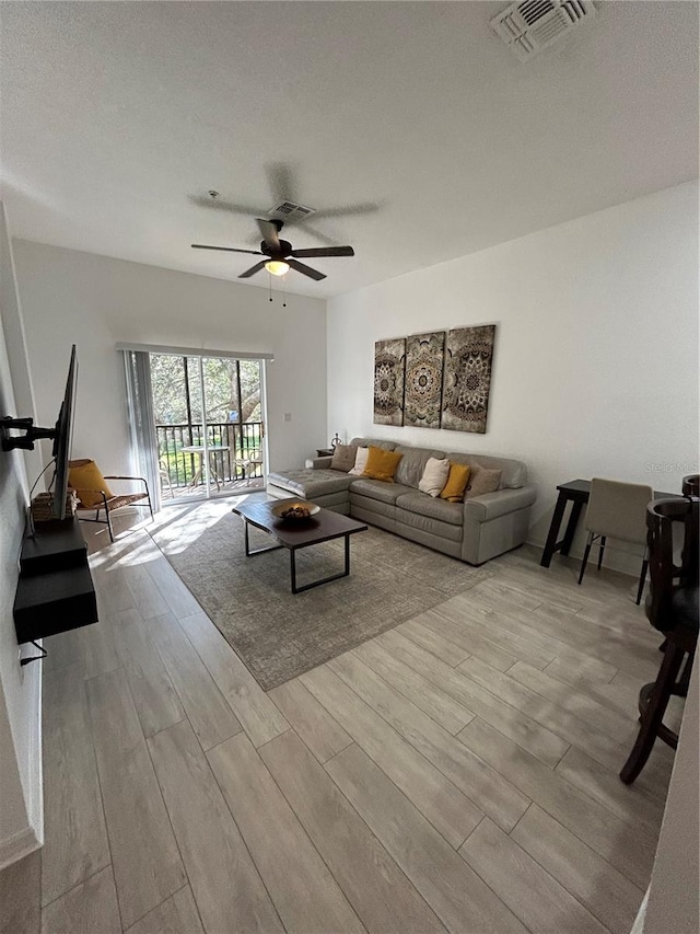 living room with light hardwood / wood-style flooring and ceiling fan