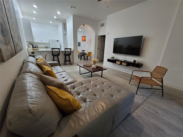 living room featuring light hardwood / wood-style floors and ceiling fan