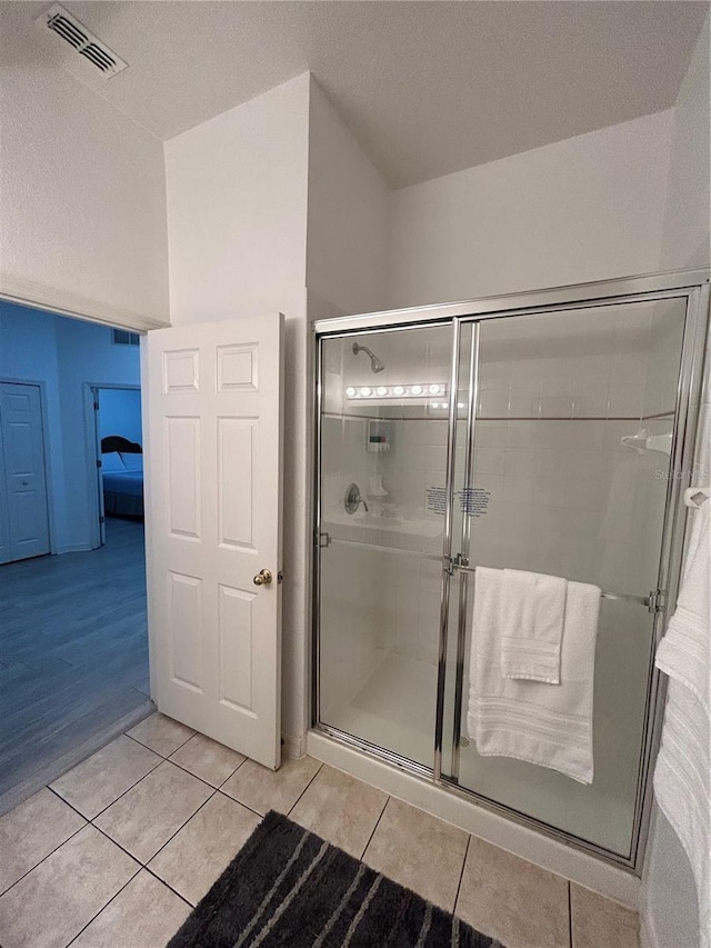 bathroom featuring a shower with door, hardwood / wood-style floors, and a textured ceiling