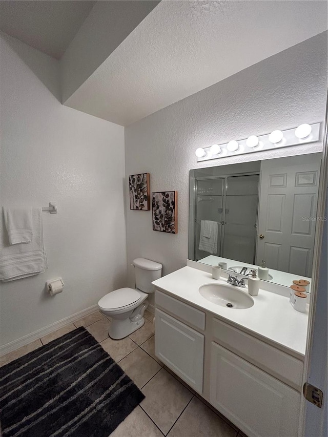 bathroom featuring vanity, a textured ceiling, toilet, and tile patterned flooring