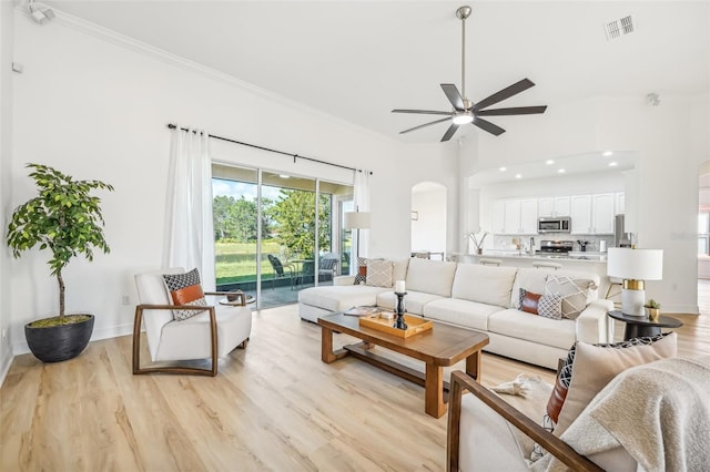 living room with ceiling fan, light hardwood / wood-style floors, and ornamental molding