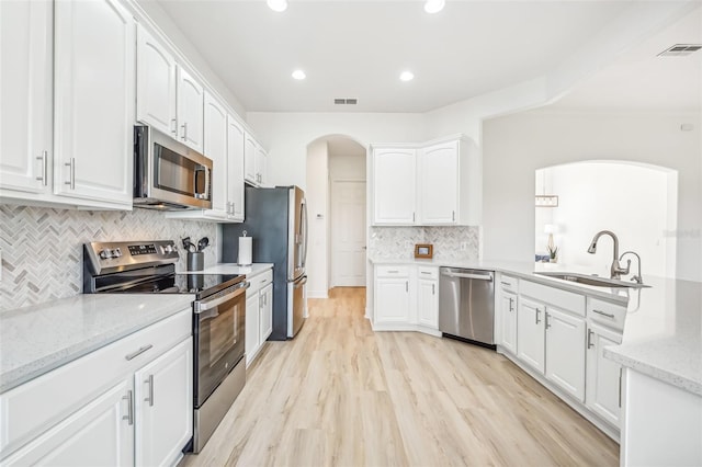 kitchen with white cabinets, stainless steel appliances, light hardwood / wood-style flooring, and sink