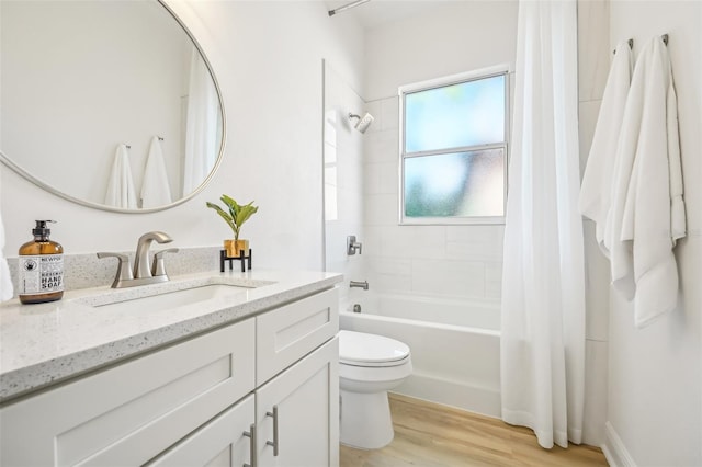 full bathroom with hardwood / wood-style floors, vanity, toilet, and shower / bath combo with shower curtain