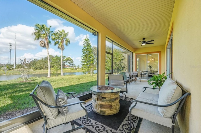 sunroom featuring a water view and ceiling fan