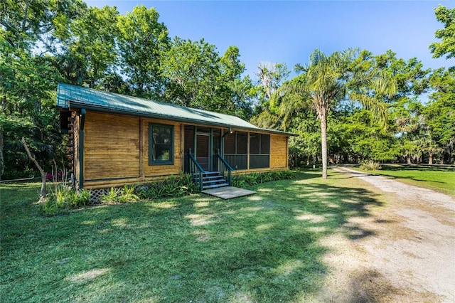 view of front of house featuring a sunroom and a front lawn