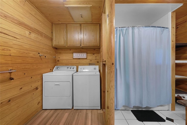 washroom featuring independent washer and dryer, wood walls, light tile patterned floors, and wood ceiling