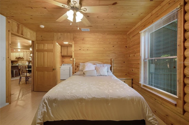 bedroom with wood ceiling, ceiling fan, light wood-type flooring, independent washer and dryer, and wood walls