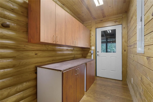 interior space with light hardwood / wood-style floors, wood ceiling, and log walls