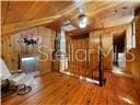 unfurnished bedroom featuring wooden walls and wood-type flooring