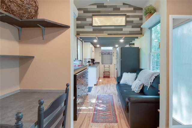 living room featuring vaulted ceiling and light wood-type flooring