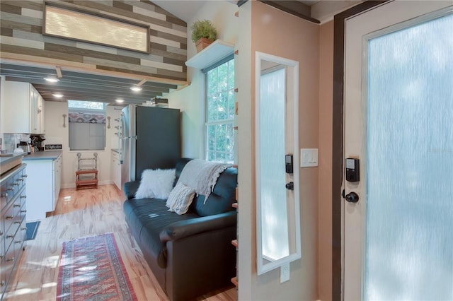 living room with vaulted ceiling and light wood-type flooring