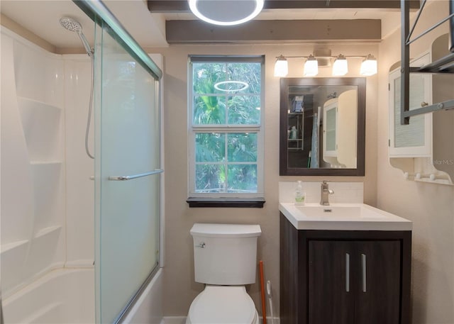 full bathroom featuring vanity, toilet, and shower / bath combination with glass door