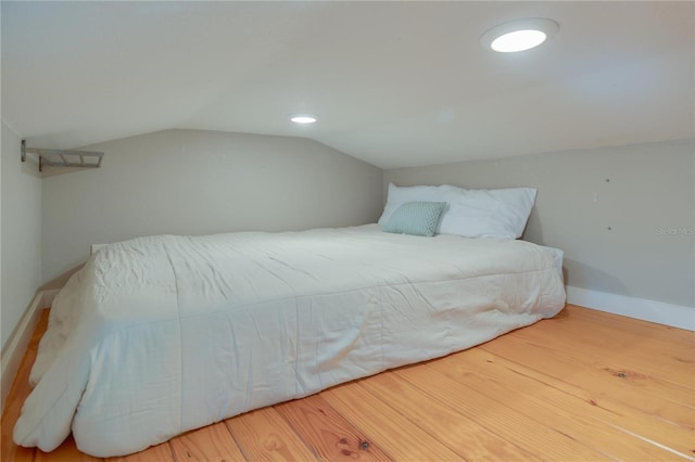 bedroom with vaulted ceiling and hardwood / wood-style floors