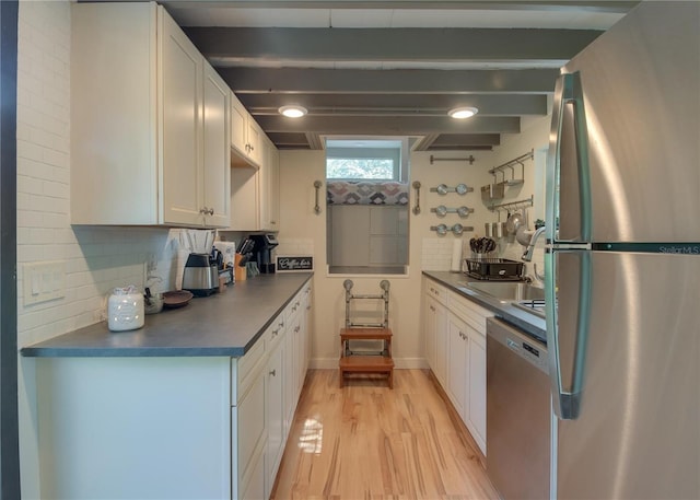 kitchen with appliances with stainless steel finishes, light wood-type flooring, white cabinetry, beam ceiling, and decorative backsplash