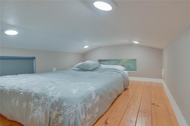 bedroom with vaulted ceiling and light hardwood / wood-style flooring