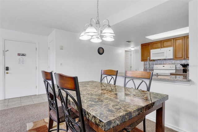 carpeted dining area featuring an inviting chandelier