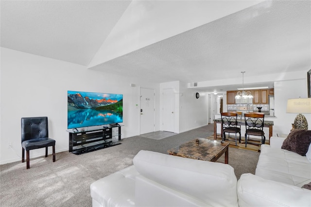 carpeted living room featuring a notable chandelier and a textured ceiling