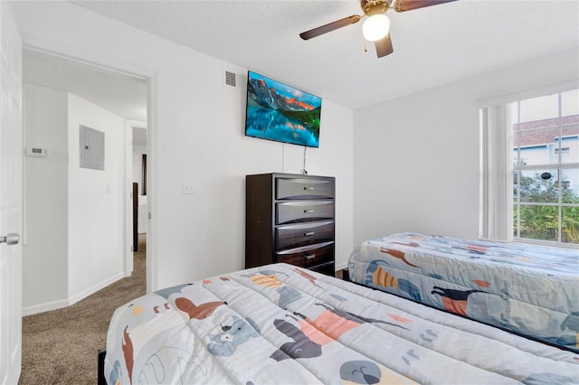 carpeted bedroom featuring ceiling fan, a textured ceiling, and electric panel