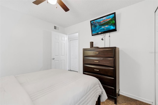 carpeted bedroom featuring a textured ceiling and ceiling fan