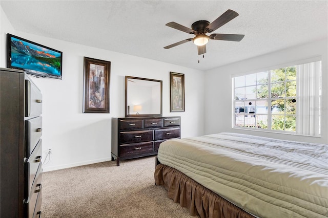 carpeted bedroom featuring ceiling fan and a textured ceiling