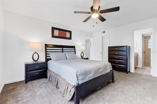 carpeted bedroom with ceiling fan and ensuite bath