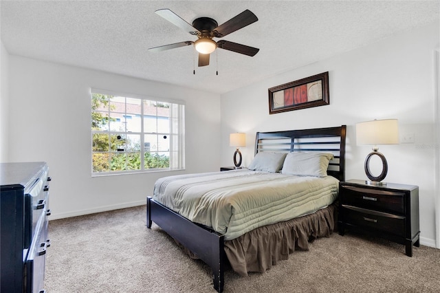 bedroom featuring a textured ceiling, light colored carpet, and ceiling fan