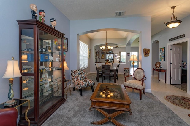 interior space with lofted ceiling, a notable chandelier, and carpet floors