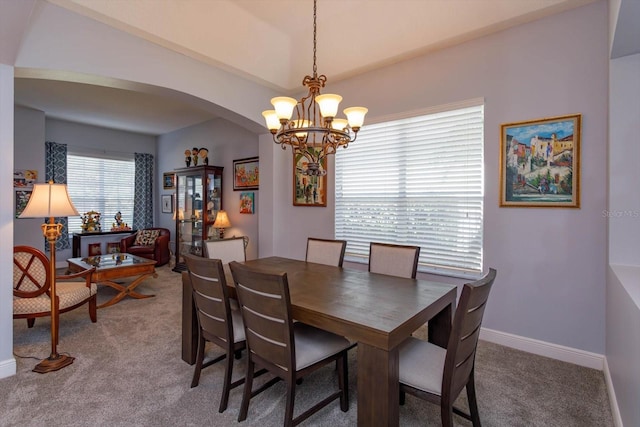 dining area with carpet floors and a chandelier