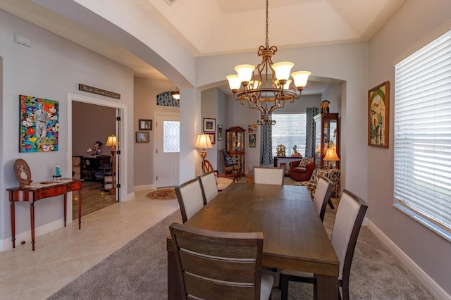 tiled dining room with a chandelier