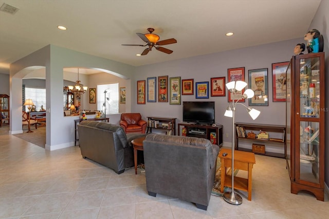 living room featuring light tile patterned floors, ceiling fan with notable chandelier, and plenty of natural light