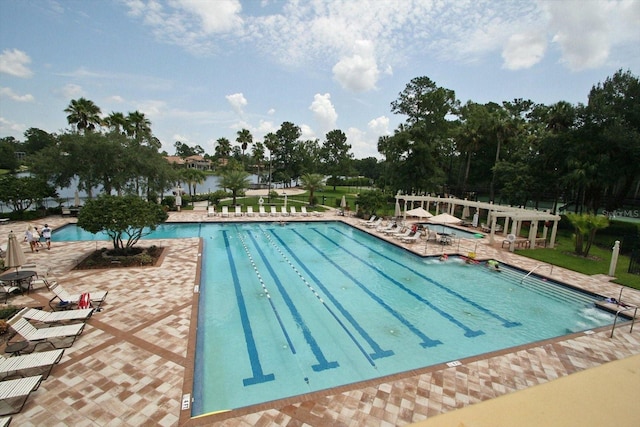 view of swimming pool featuring a patio and a water view