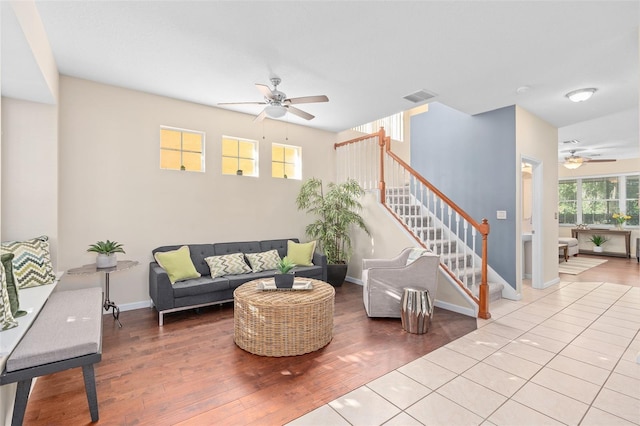 living room with stairway, ceiling fan, wood finished floors, and visible vents
