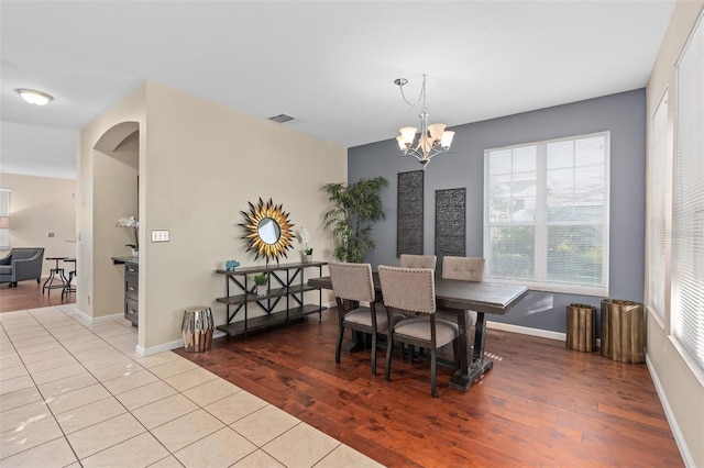 dining space with visible vents, wood finished floors, and a chandelier